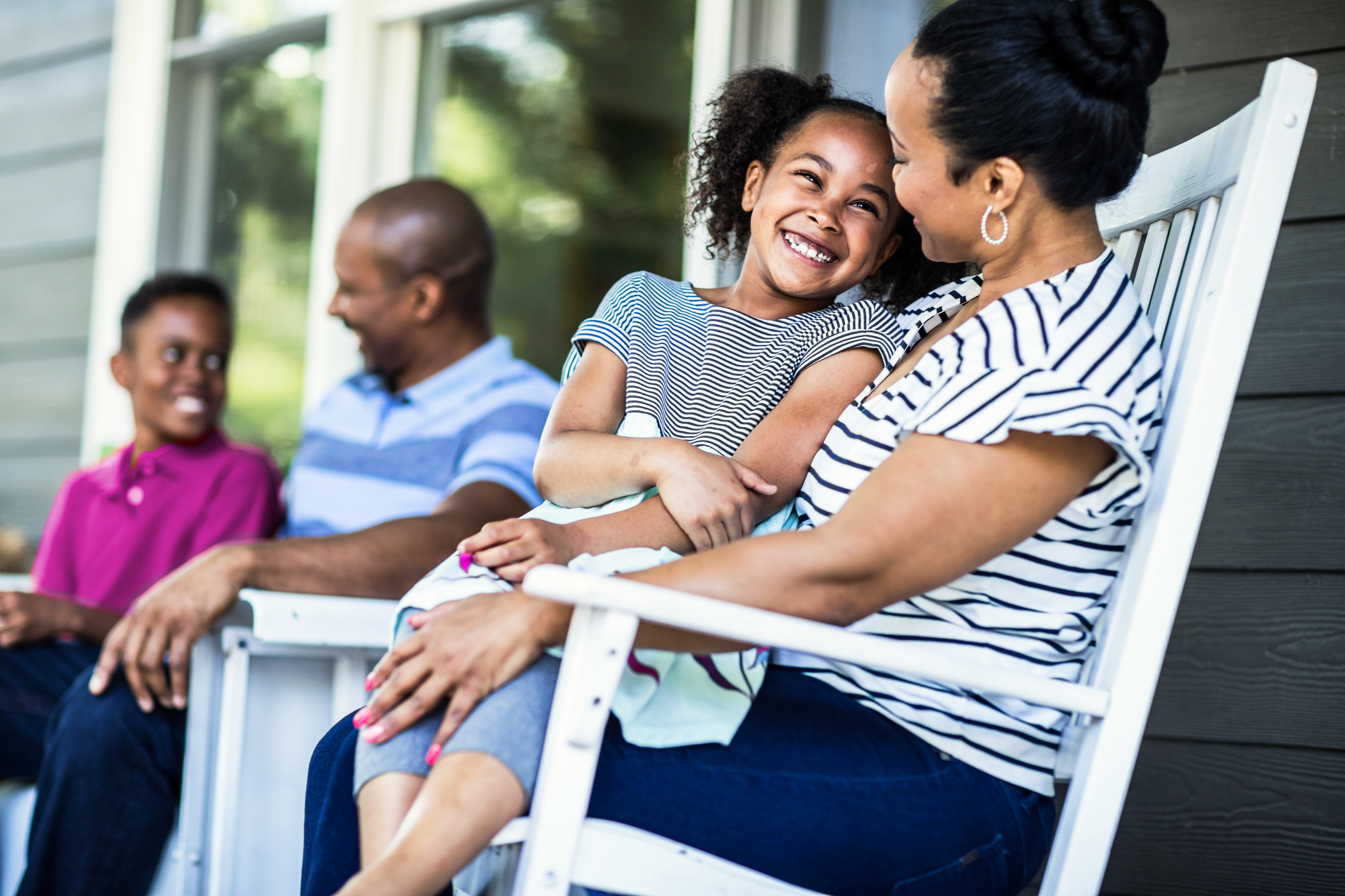 Family hugging on porch.